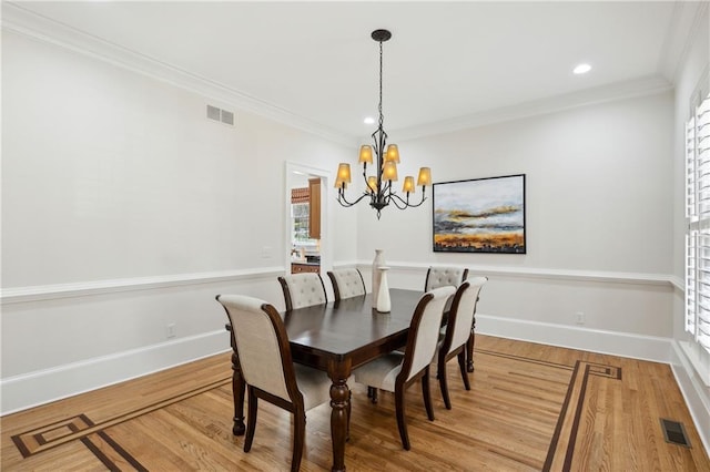 dining area featuring visible vents, an inviting chandelier, and wood finished floors