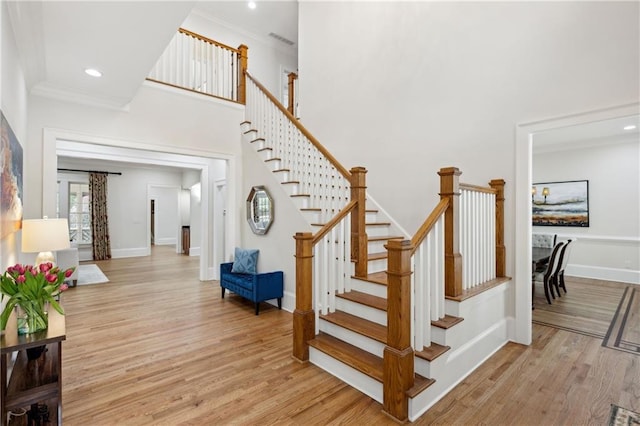 staircase featuring recessed lighting, baseboards, wood finished floors, and crown molding