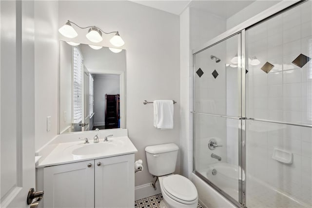 bathroom with baseboards, enclosed tub / shower combo, toilet, and vanity