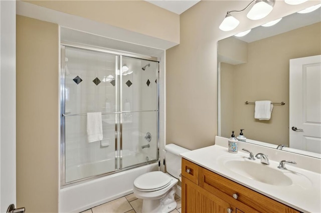 bathroom with tile patterned floors, toilet, shower / bath combination with glass door, and vanity