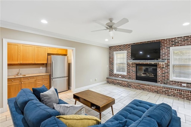 living room with light tile patterned floors, baseboards, brick wall, ceiling fan, and crown molding