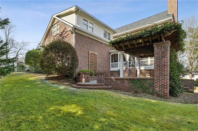 view of side of home featuring stairway, a yard, brick siding, and a chimney