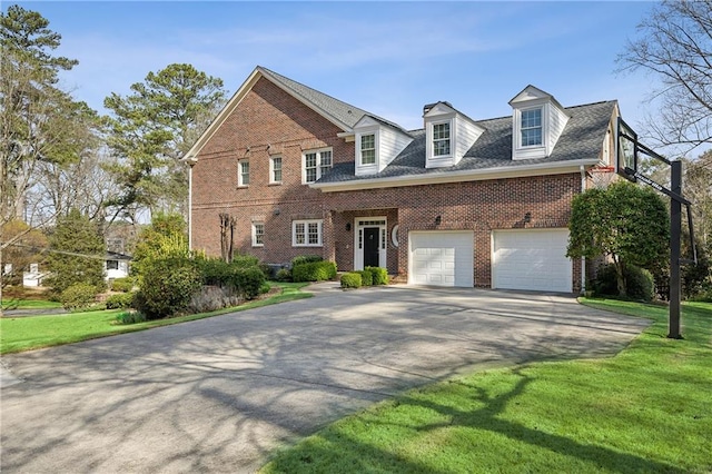 view of front of house with brick siding, concrete driveway, and a front lawn