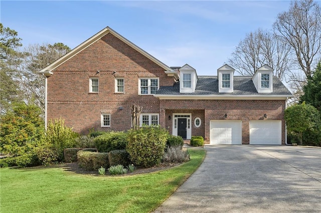 view of front of home featuring brick siding, driveway, an attached garage, and a front yard