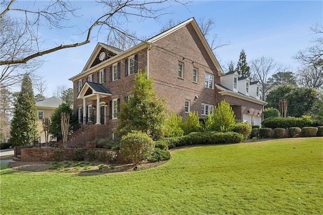 view of side of property featuring a garage, a yard, and brick siding