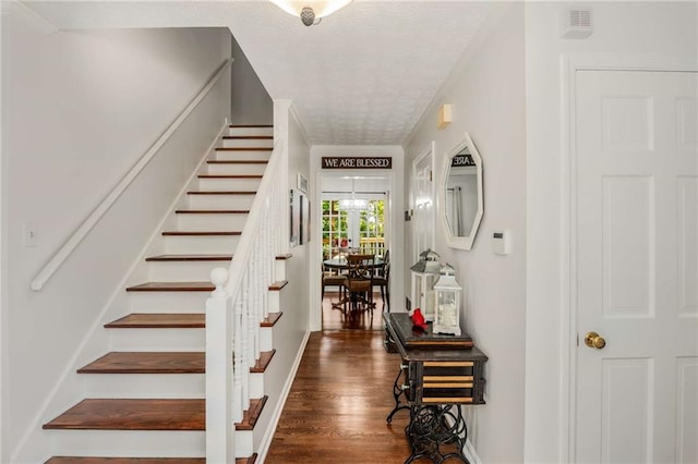 stairs with hardwood / wood-style flooring and crown molding