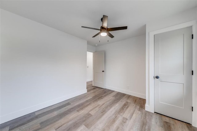 unfurnished bedroom featuring light wood-type flooring, baseboards, and a ceiling fan