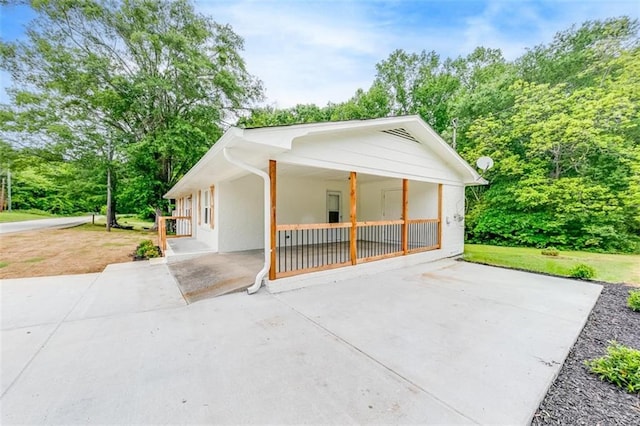 view of property exterior with covered porch and stucco siding