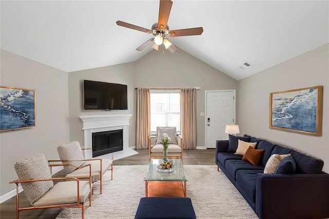 living room with light hardwood / wood-style floors, vaulted ceiling, and ceiling fan