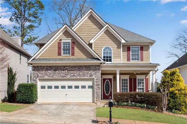 view of front of home featuring driveway, roof with shingles, a front lawn, a garage, and stone siding