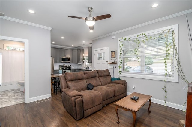 living room featuring ornamental molding, ceiling fan, and dark wood-type flooring