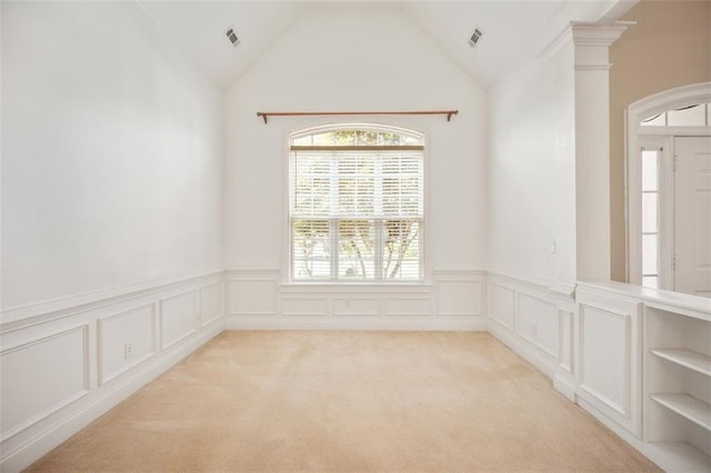 1979 Spivey Village Dr, Jonesboro, GA 30236 - empty room featuring a wainscoted wall, a decorative wall, arched walkways, light carpet, and vaulted ceiling