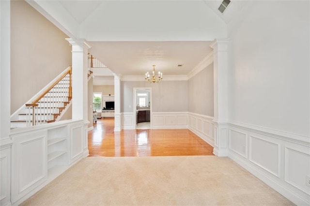 1979 Spivey Village Dr, Jonesboro, GA 30236 - spare room with decorative columns, light carpet, a chandelier, stairway, and wainscoting