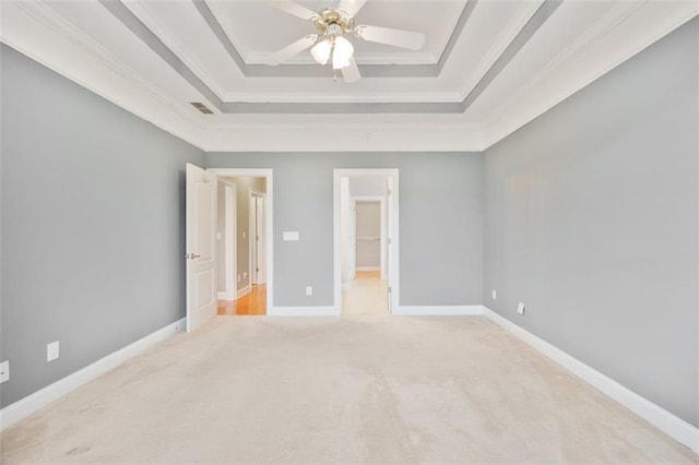 1979 Spivey Village Dr, Jonesboro, GA 30236 - unfurnished bedroom featuring a tray ceiling, carpet, ornamental molding, a walk in closet, and a ceiling fan