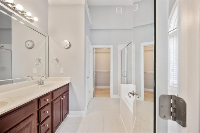 1979 Spivey Village Dr, Jonesboro, GA 30236 - bathroom featuring a walk in closet, double vanity, a stall shower, tile patterned flooring, and tiled bath