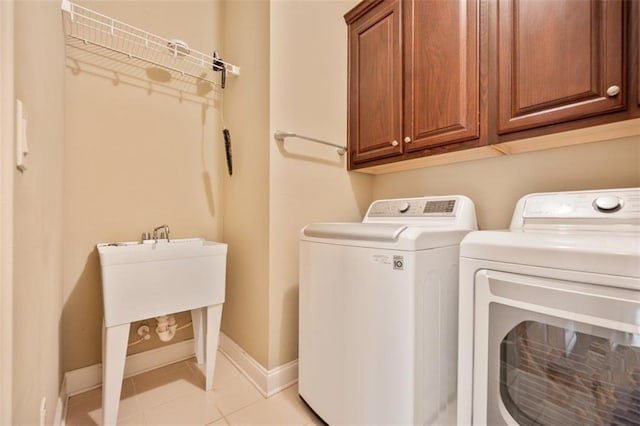 1979 Spivey Village Dr, Jonesboro, GA 30236 - laundry room featuring washing machine and dryer, cabinet space, and light tile patterned flooring