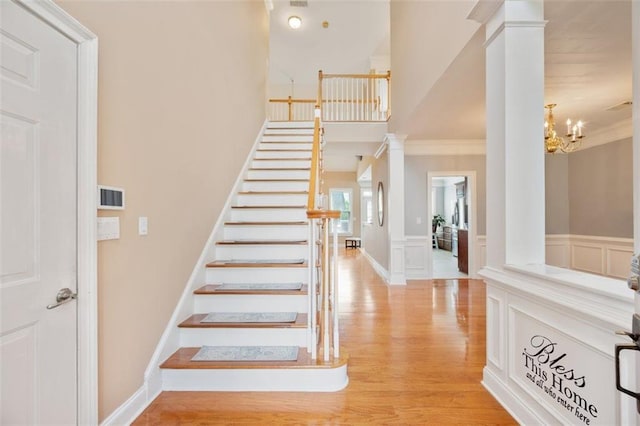 1979 Spivey Village Dr, Jonesboro, GA 30236 - stairs with wood finished floors, ornamental molding, ornate columns, wainscoting, and a chandelier