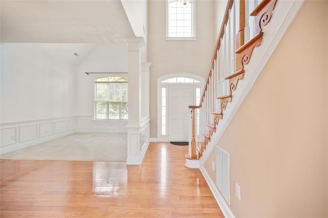 1979 Spivey Village Dr, Jonesboro, GA 30236 - foyer featuring wood finished floors, high vaulted ceiling, stairs, and ornate columns