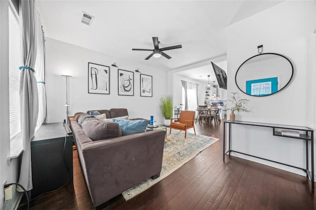 living room with ceiling fan and dark hardwood / wood-style flooring