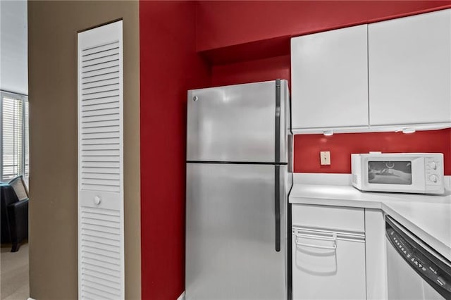 1421 Peachtree St NE Unit 212, Atlanta, GA 30309 - kitchen featuring appliances with stainless steel finishes, light countertops, and white cabinetry