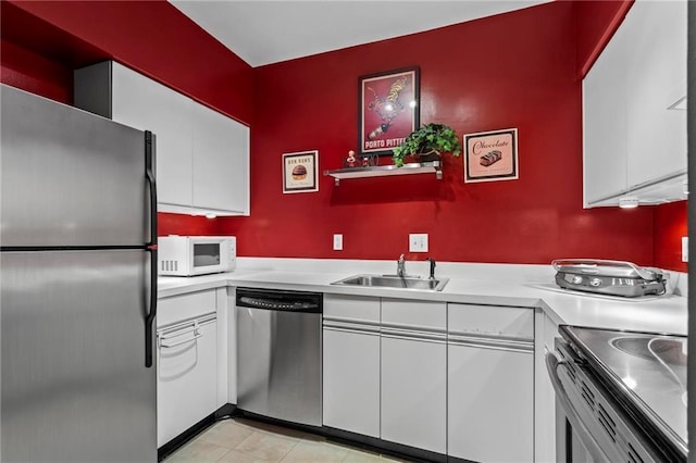 1421 Peachtree St NE Unit 212, Atlanta, GA 30309 - kitchen with appliances with stainless steel finishes, a sink, light countertops, and white cabinetry