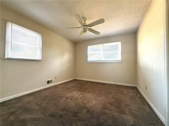 carpeted spare room featuring ceiling fan and a textured ceiling