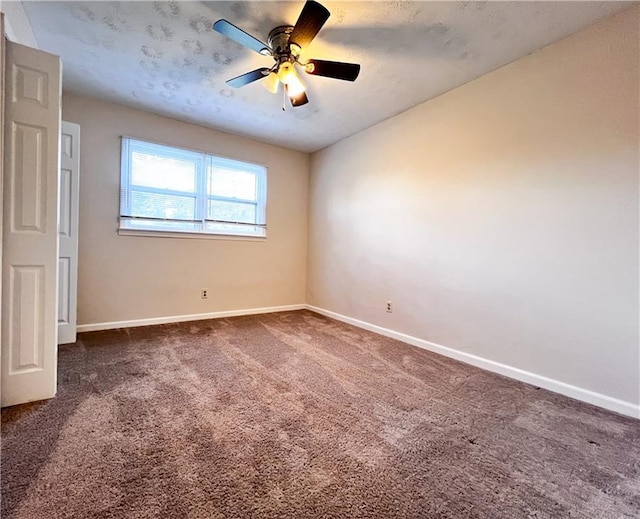 carpeted spare room with ceiling fan