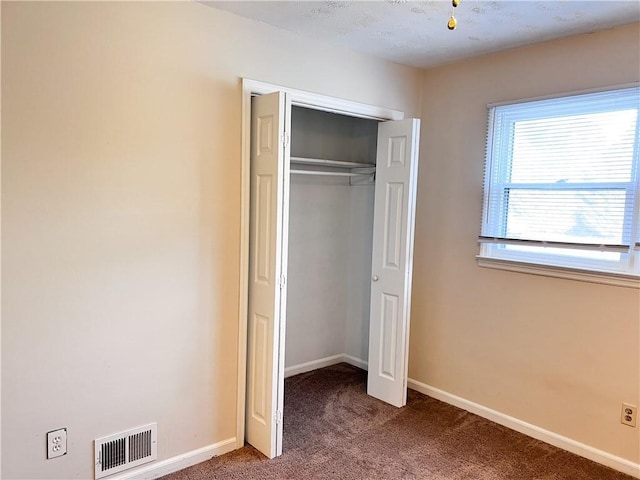 unfurnished bedroom featuring a closet and carpet floors