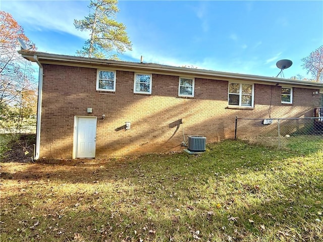 rear view of property featuring a yard and central AC