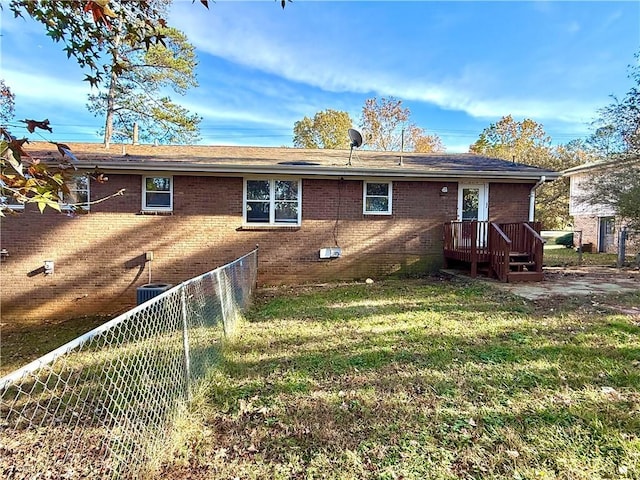 rear view of property featuring a lawn