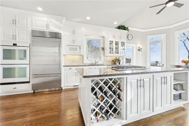 kitchen featuring stone counters, decorative backsplash, appliances with stainless steel finishes, and white cabinets