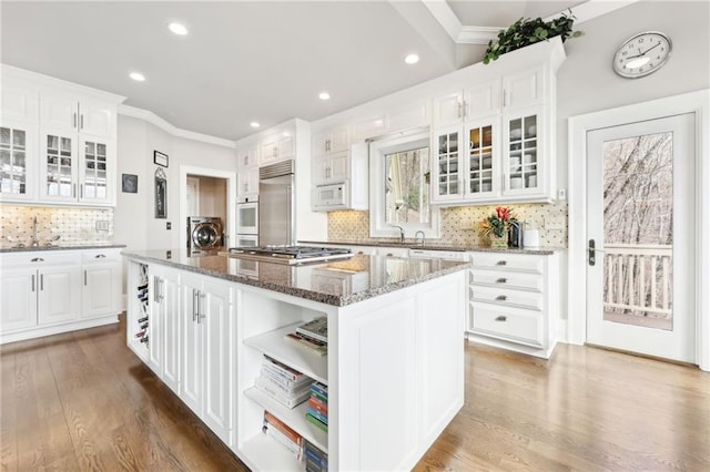 kitchen featuring open shelves, white appliances, white cabinets, and a center island