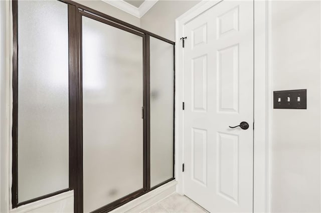 full bathroom featuring a stall shower, crown molding, and tile patterned flooring