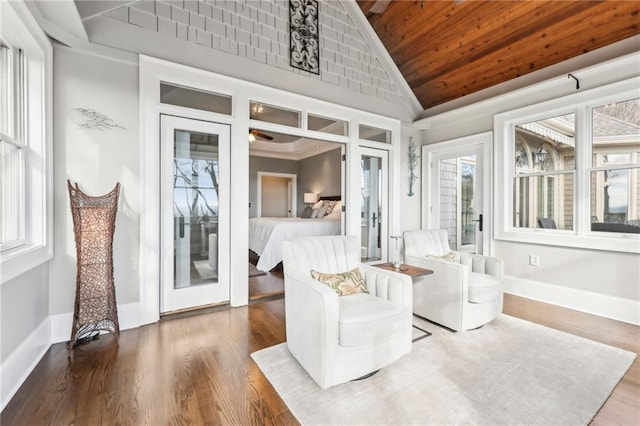 interior space with baseboards, wood ceiling, lofted ceiling, and wood finished floors