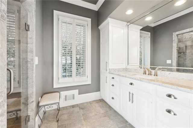 bathroom featuring a shower with door, visible vents, crown molding, baseboards, and vanity