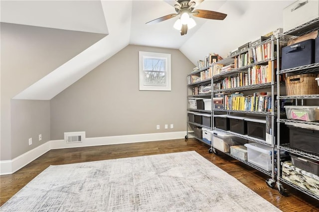 interior space with wood finished floors, baseboards, visible vents, ceiling fan, and vaulted ceiling