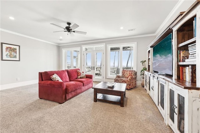 living area featuring visible vents, light colored carpet, ceiling fan, and crown molding