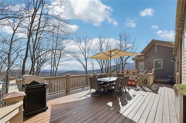 wooden terrace featuring outdoor dining space and a grill