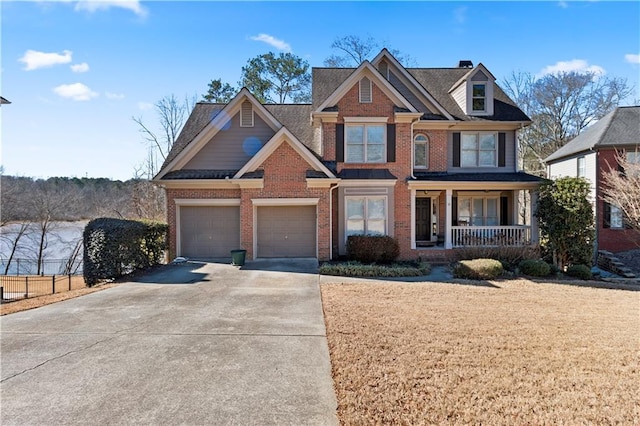 craftsman-style home featuring a porch, brick siding, driveway, and a garage