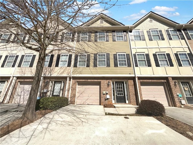 townhome / multi-family property featuring concrete driveway, brick siding, and a garage