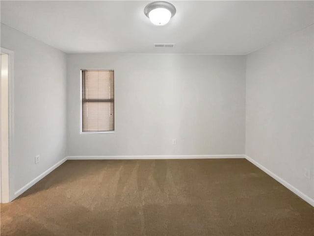 spare room featuring baseboards, visible vents, and carpet floors