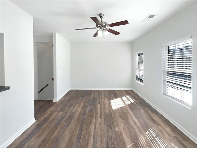 spare room featuring visible vents, baseboards, ceiling fan, and wood finished floors