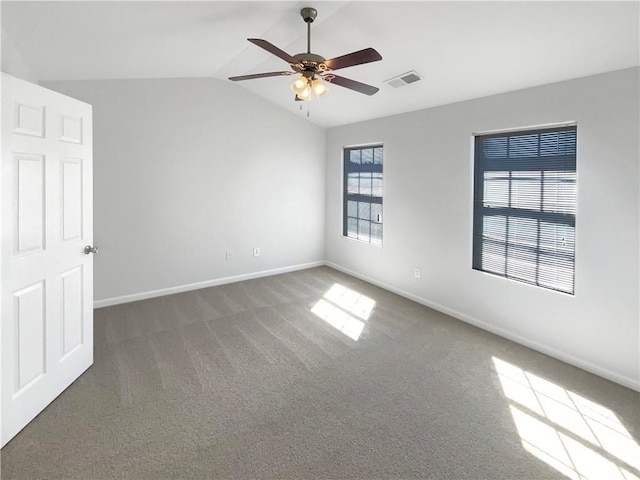 empty room featuring vaulted ceiling, baseboards, visible vents, and carpet floors