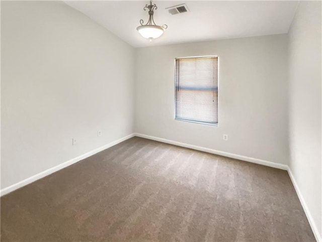 spare room with visible vents, carpet, and baseboards