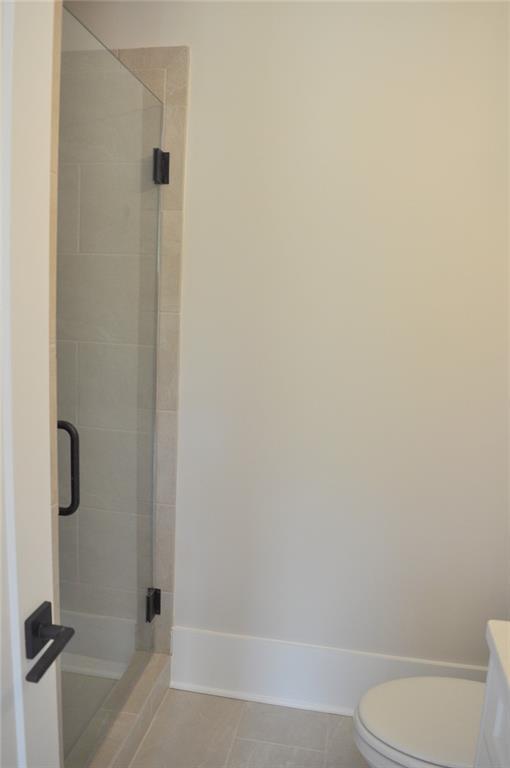 285 White St Unit 4, Marietta, GA 30060 - bathroom with toilet, a stall shower, tile patterned floors, and vanity
