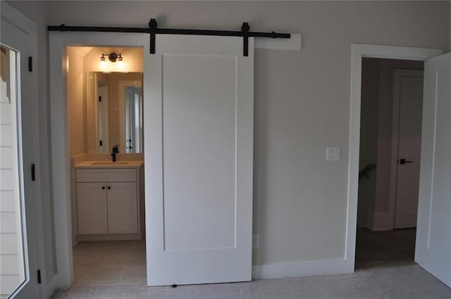 285 White St Unit 4, Marietta, GA 30060 - unfurnished bedroom with a sink, connected bathroom, a barn door, and baseboards