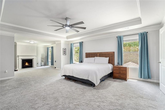5696 Walnut Mill Ln, Powder Springs, GA 30127 - carpeted bedroom with a raised ceiling, ornamental molding, multiple windows, ceiling fan, and a warm lit fireplace