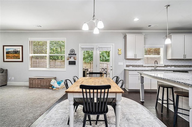 5696 Walnut Mill Ln, Powder Springs, GA 30127 - dining area with healthy amount of natural light, ornamental molding, and a chandelier