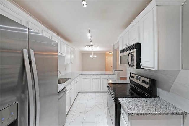 kitchen with white cabinetry, sink, decorative light fixtures, and stainless steel appliances