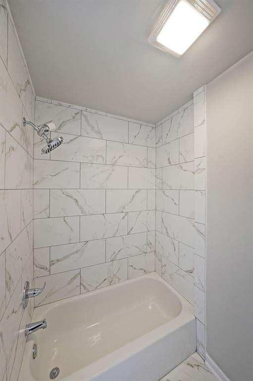 bathroom with tiled shower / bath combo